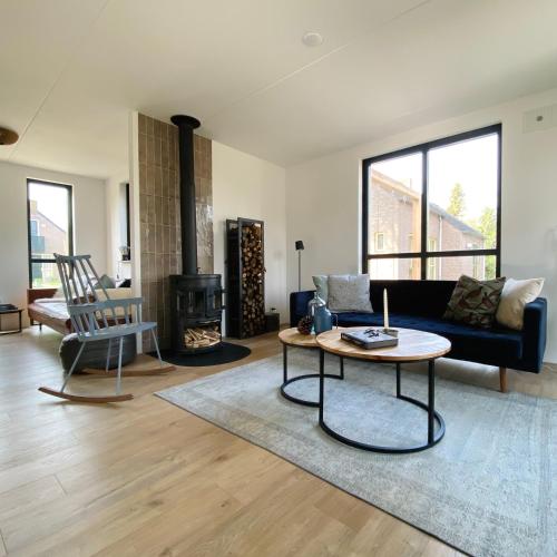 a living room with a couch and a table at Huisje Hygge - luxe bungalow met grote tuin in Ewijk
