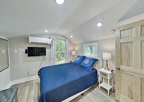 une chambre avec un lit bleu et une télévision dans l'établissement Asheville Black Mountain Escape, à Black Mountain