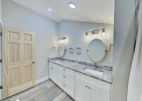 une salle de bain avec deux lavabos et un grand miroir dans l'établissement Asheville Black Mountain Escape, à Black Mountain