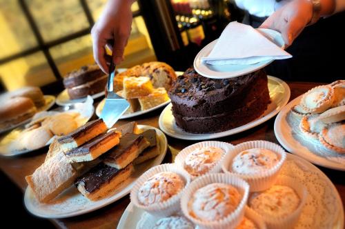 a table full of different types of cakes and pastries at The Bear Hotel in Devizes