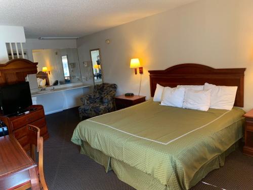 ウィリアムズバーグにあるMERRIMAC INN & SUITESのベッドとテレビが備わるホテルルームです。