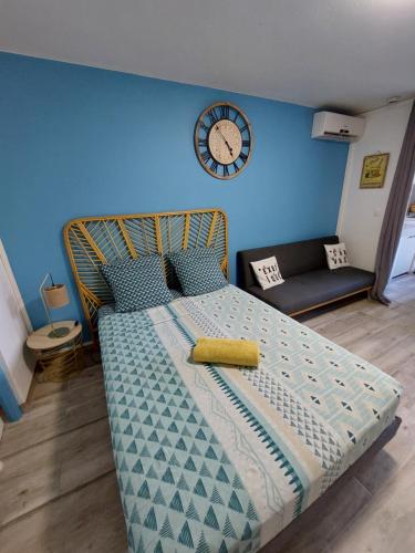 - une chambre dotée d'un lit avec une horloge murale dans l'établissement Studio A14 près de la mer Village du Diamant, au Diamant