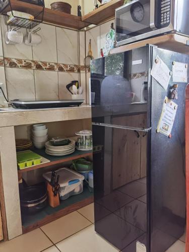 a kitchen with a refrigerator and a microwave at Greenhouse Lofts Miravalles in Aguas Claras
