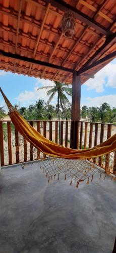 a hammock on a porch with a view of the ocean at Maluhia Lofts in Icaraí