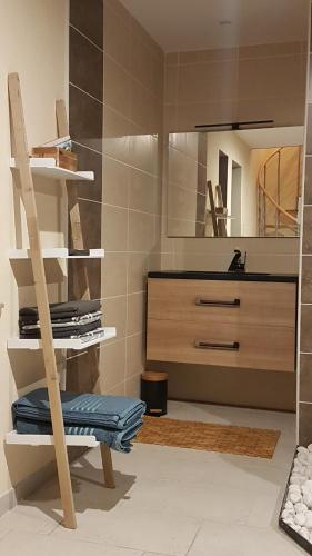 La salle de bains est pourvue d'un miroir et d'une étagère en bois. dans l'établissement Cosy Love & Spa Love room avec spa, hammam et sauna privatif, à Cemboing