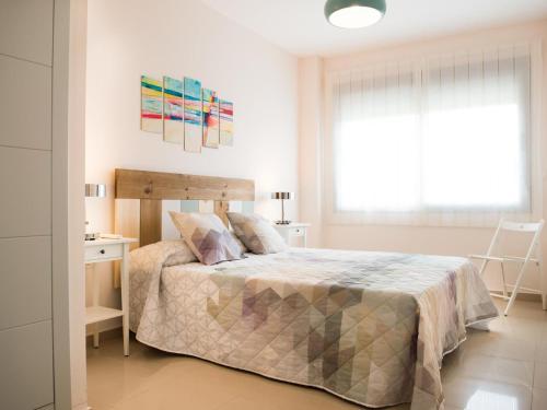 Schlafzimmer mit einem Bett, einem Schreibtisch und einem Fenster in der Unterkunft Apartamento Puerta del Sol in Conil de la Frontera