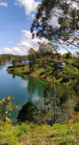 a view of a lake with a house on a hill at Ecolodge Bahia del Peñón in Guatapé