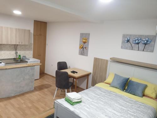 ein Schlafzimmer mit einem Bett und einem Tisch sowie eine Küche in der Unterkunft City center apartment 2 in Niš