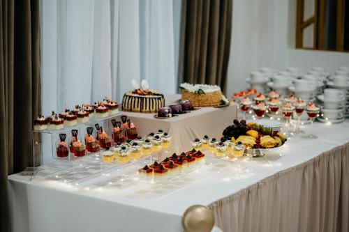 einen Tisch mit einem Buffet mit Desserts und Getränken in der Unterkunft Hotel Resident in Nowa Sarzyna