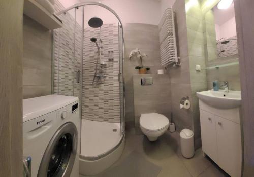 a bathroom with a washing machine and a sink at Sunset Studio - Free Parking - Fast Internet - Close to Everything in Poznań