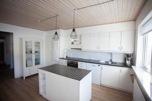 eine Küche mit weißen Schränken und einer schwarzen Arbeitsplatte in der Unterkunft 3BR - Townhouse - Free Parking - Tórshavn in Tórshavn