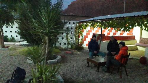 een groep mensen die buiten een gebouw zitten bij WadiRum Village Lodge in Wadi Rum