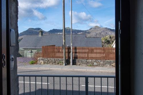 a view from a window of a house with a fence at Homely cottage with garden and mountain-view in Blaenau-Ffestiniog