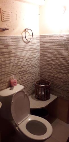 a bathroom with a toilet and a wicker basket at Vivenda Agostinho (Casa de Férias) in Arcos de Valdevez