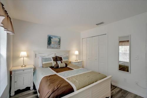 a white bedroom with a large bed and two lamps at SOLANA 7 Bed Rooms FAMILY VACATION VILLA-Private Pool and SPA in Davenport
