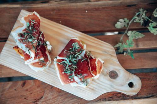 dos sándwiches sentados en una tabla de cortar de madera en Selina Secret Garden Lisbon by IKIGAI Global Hospitality, en Lisboa