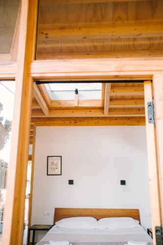 a bed in a room with wooden ceilings at miCielo - Baumhäuser in Vejer de la Frontera