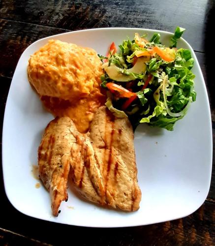 a plate of food with meat and a salad at Hotel Minca - La Casona in Minca