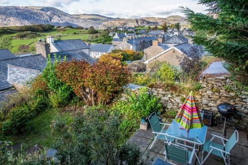 a patio with a table and chairs and a umbrella at Homely cottage with garden and mountain-view in Blaenau-Ffestiniog