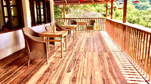 a porch with chairs and tables on a deck at Hotel Minca - La Casona in Minca