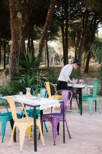 a woman standing in front of tables and chairs at miCielo - Baumhäuser in Vejer de la Frontera