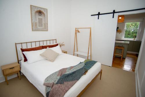 a bedroom with a white bed and a mirror at Willow McLaren Vale in McLaren Vale