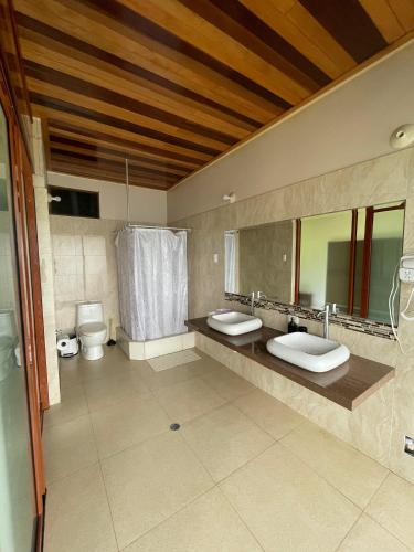 a bathroom with two sinks and two toilets at Mercedes Lodge in San Ramón