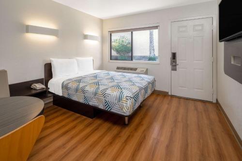 a small room with a bed and a window at Motel 6-Santa Barbara, CA - State Street in Santa Barbara