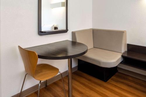 a small table and chair in a room with a mirror at Motel 6-Santa Barbara, CA - State Street in Santa Barbara