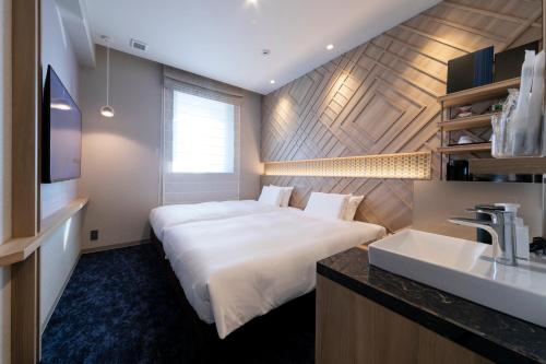a hotel room with a large bed and a sink at S-Peria Hotel Fukuoka Nakasu in Fukuoka