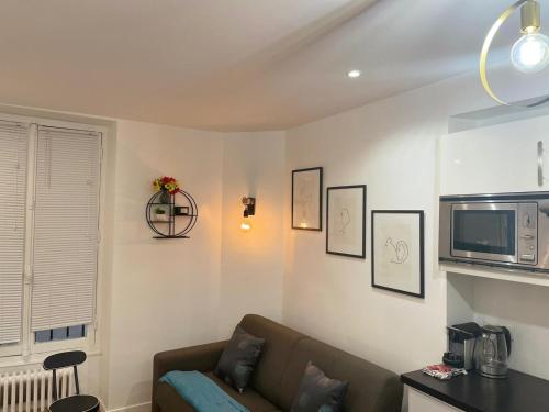 - un salon avec un canapé et un four micro-ondes dans l'établissement Paris Cosy Apartment Opéra Vendome Galeries Lafayette, à Paris