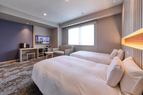 Un pat sau paturi într-o cameră la S-Peria Hotel Fukuoka Nakasu