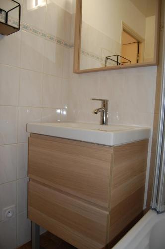 uma casa de banho com um lavatório e um espelho em Appartement agréable à deux pas du plan d'eau em Embrun