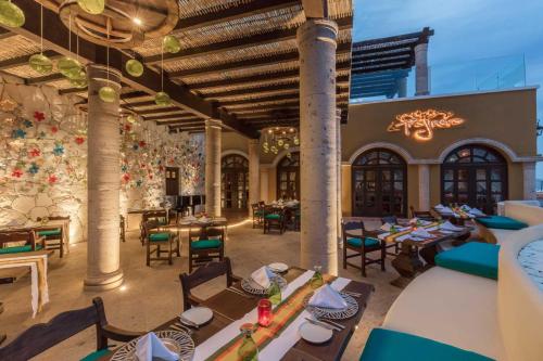 a restaurant with tables and chairs in a building at Hacienda Encantada Resort & Spa in Cabo San Lucas