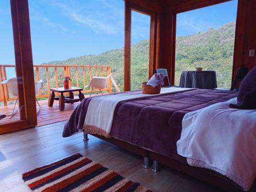 a bedroom with a bed with a view of a mountain at Glamping Paraiso en La montaña in La Calera