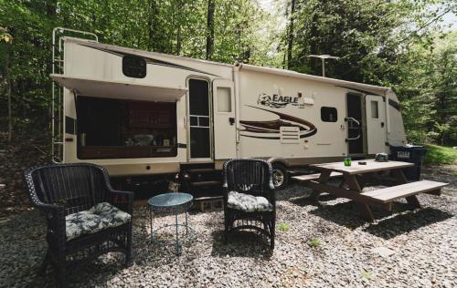 a rv with a picnic table and chairs in front of it at Rv adventure Roscoe Pet friendly in Roscoe