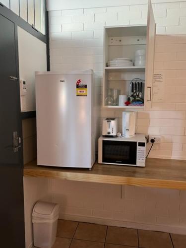 a white refrigerator freezer sitting on top of a counter at Maryborough City Motel in Maryborough