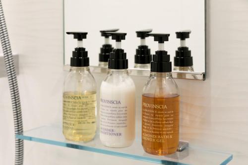 a shelf with four bottles of disinfectants on it at S-Peria Hotel Fukuoka Nakasu in Fukuoka