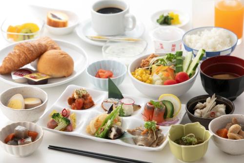 a table topped with plates of food and bowls of food at S-Peria Hotel Fukuoka Nakasu in Fukuoka