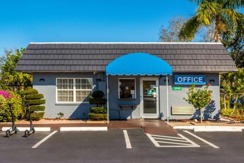 a blue and white office building with a parking lot at SureStay Hotel by Best Western Sarasota Lido Beach in Sarasota