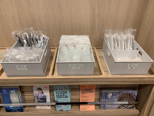 three boxes sitting on a shelf with books at Smile Hotel Osaka Nakanoshima in Osaka