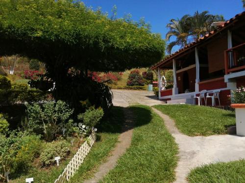 a house with a tree next to a driveway at Finca Mirador la Giralda in Roldanillo
