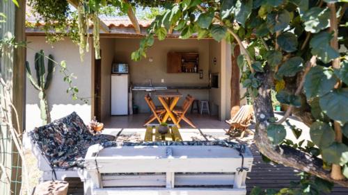 a patio with a couch and a table and a kitchen at Recanto Sol&Mar - Centrinho da Praia do Rosa in Praia do Rosa