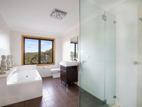 La salle de bains est pourvue d'une baignoire, d'un lavabo et d'une douche. dans l'établissement Postcards From The Edge, à Blackheath