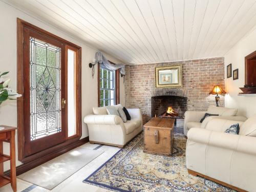 a living room with two couches and a fireplace at The Coach House in Mount Victoria
