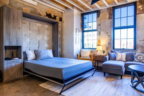 a bedroom with a bed and a couch and a chair at Sterchi Lofts Getaway - Downtown Knoxville in Knoxville