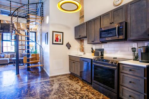 eine Küche mit Holzschränken und einem Herd in der Unterkunft Sterchi Lofts Getaway - Downtown Knoxville in Knoxville