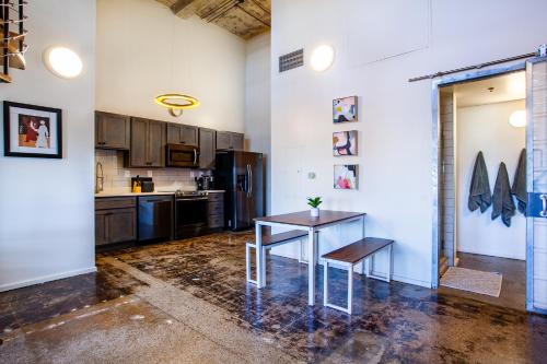a kitchen with a table and a refrigerator at Sterchi Lofts Getaway - Downtown Knoxville in Knoxville