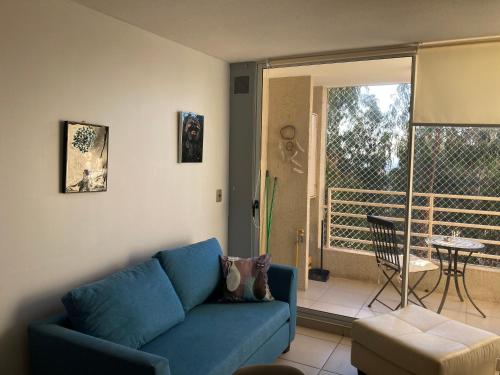 een woonkamer met een blauwe bank en een balkon bij Depto en Costa Algarrobo Norte con wifi in Algarrobo