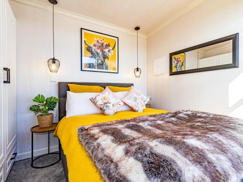Mangateitei Views - Rangataua Tiny Home في أوهاكيون: غرفة نوم بسرير اصفر في غرفة